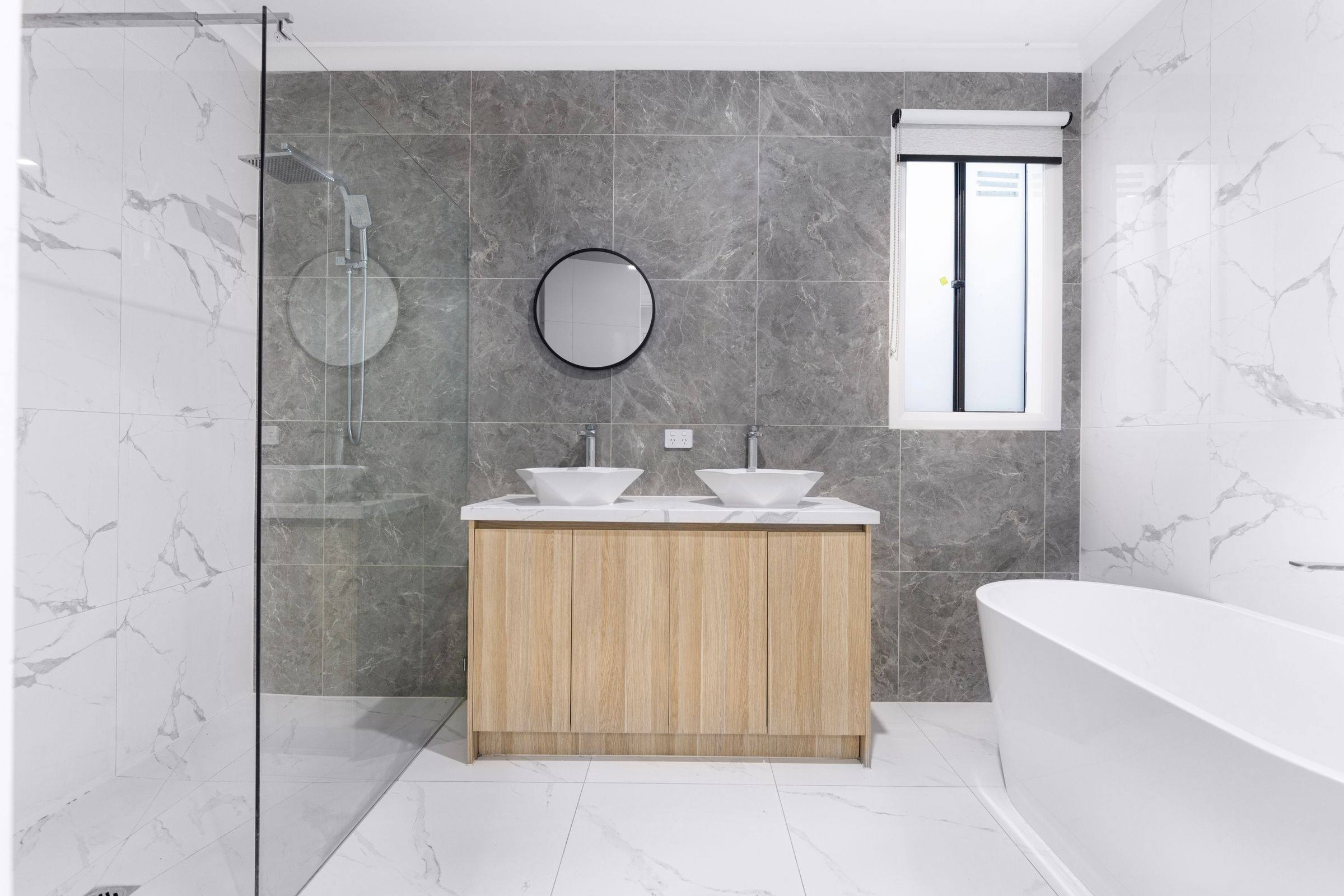 Modern bathroom with a double vanity, freestanding tub and glass shower